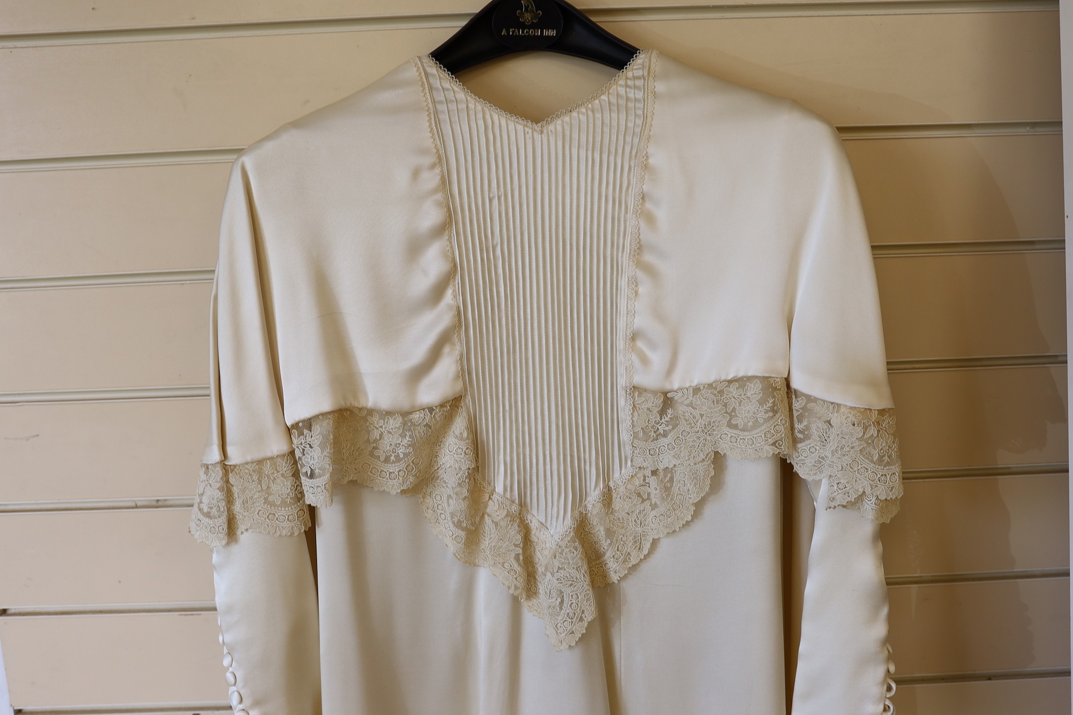 A 1970's cream satin wedding dress, trimmed with 19th century point de gaze, hand made needlepoint lace